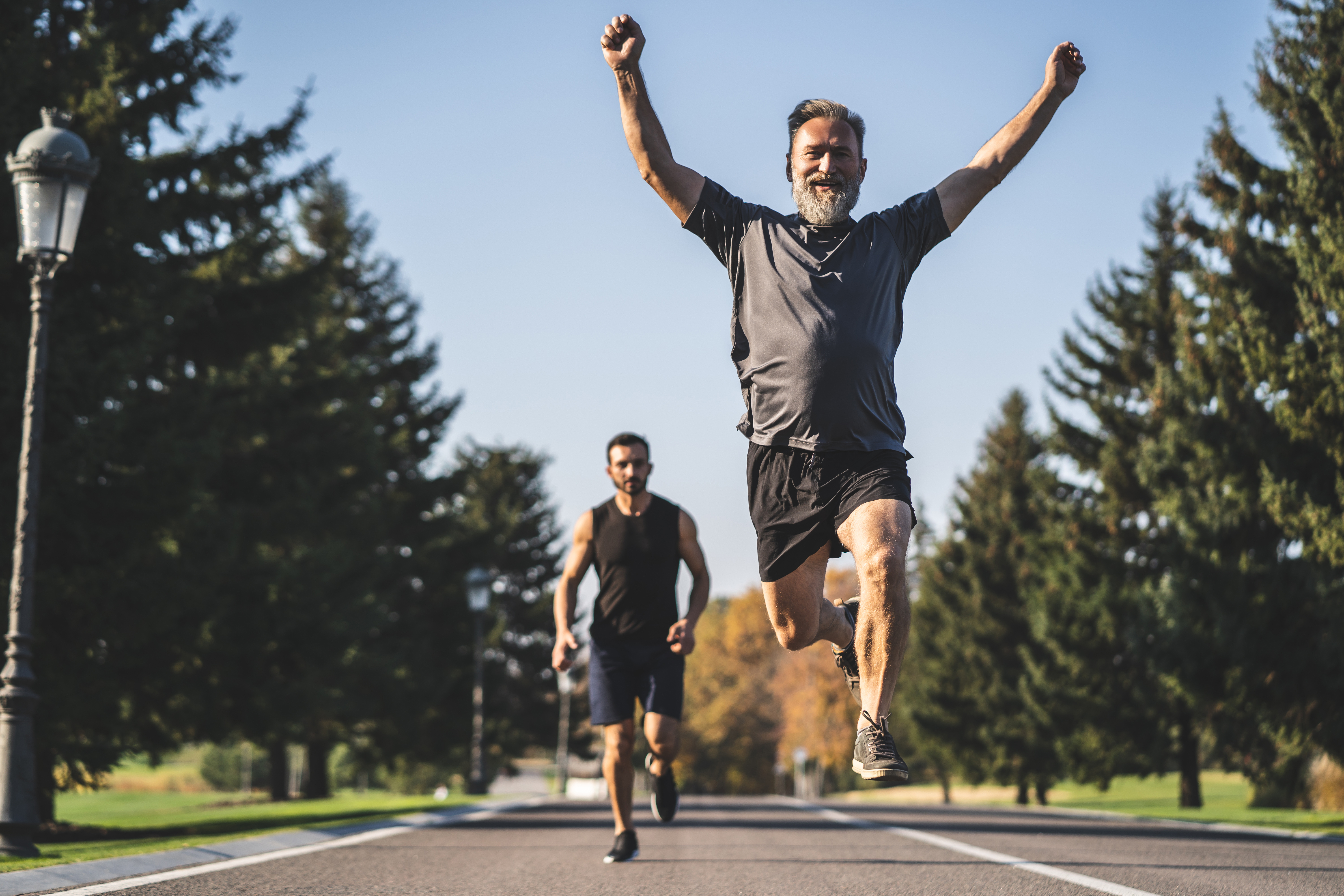 The two men running on the road in the park Coureur individuel